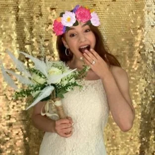 A bride at the booth wearing a digital flower crown filter over her hair