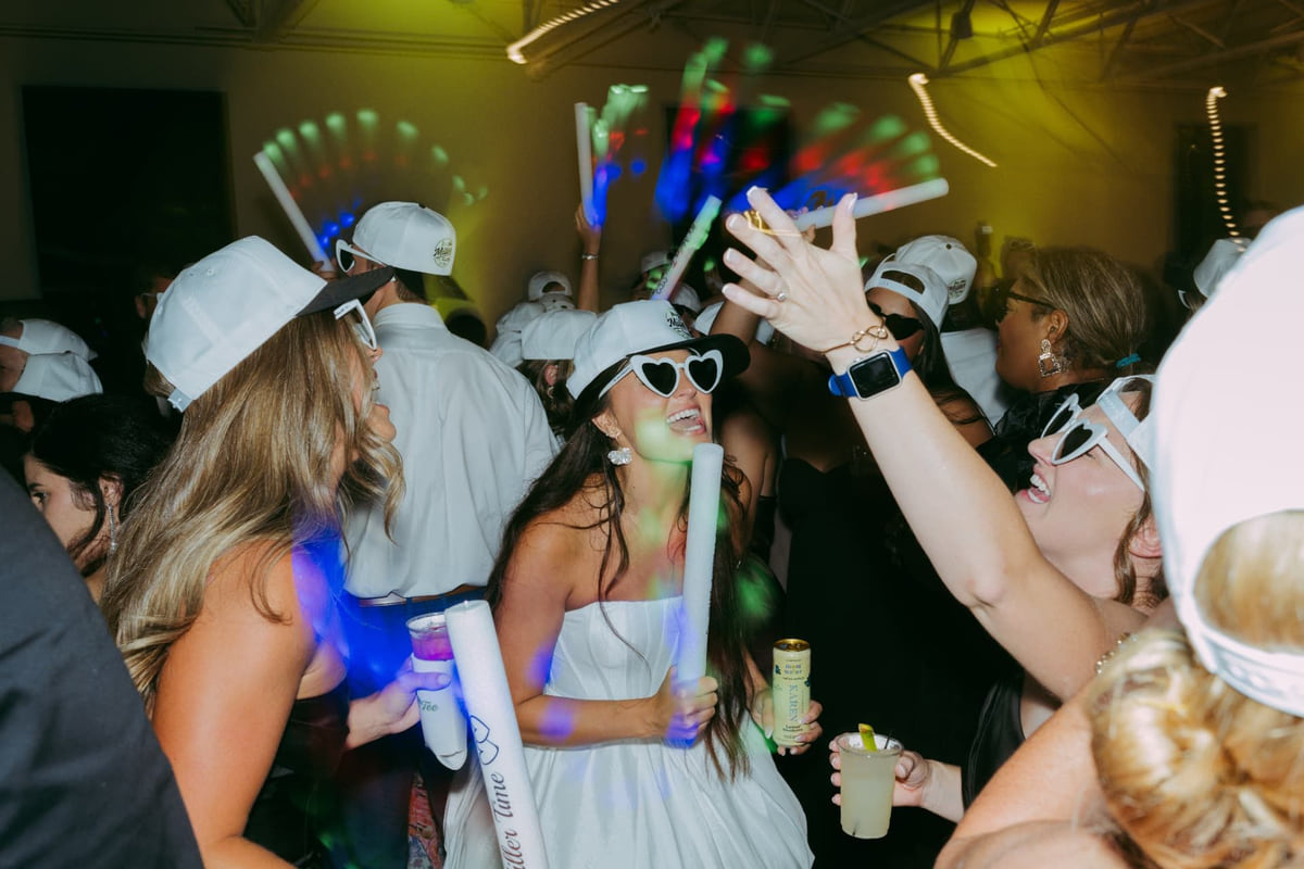 Wedding guests dancing with glow sticks and light batons at a packed SoundChoice DJ reception
