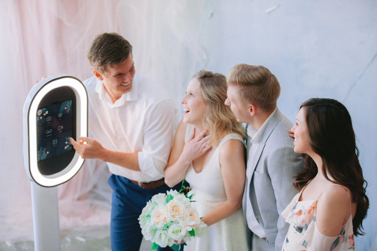 Wedding guests posing together in front of an open-air ring light photobooth