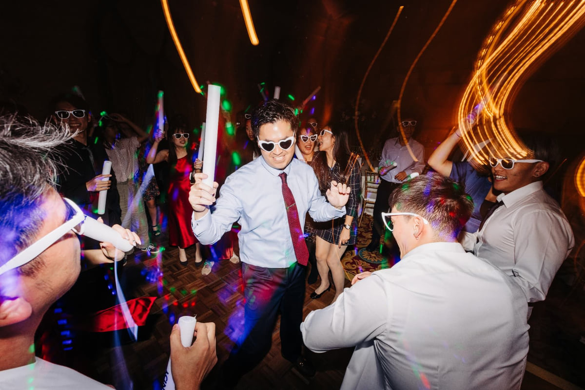 Guests dancing with glowing batons late in the reception